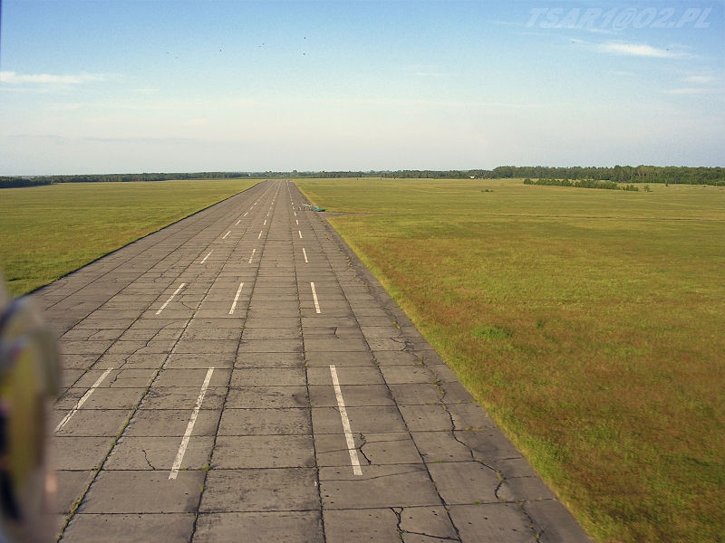Autor: Tsar1 z polskiej Wikipedii [Public domain], Wikimedia Commons / Lotnisko Nowe Miasto nad Pilicą - zdjęcie pasa startowego wykonane dnia 07.06.2007 - 